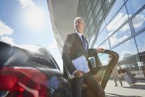 Businessman arriving at airport getting out of town car — Stock Photo