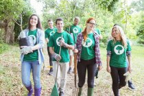 Voluntarios ambientalistas sonrientes plantando nuevo árbol - foto de stock