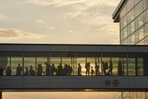 Silhouette persone a piedi in aeroporto ponte cielo — Foto stock
