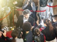 Celebrity being interviewed and photographed by paparazzi photographers at red carpet event — Stock Photo
