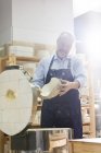 Homem examinando cerâmica no forno no estúdio — Fotografia de Stock