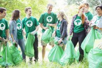 Улыбающиеся волонтеры-экологи собирают мусор — стоковое фото