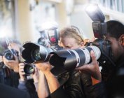 Primer plano de fotógrafos paparazzi apuntando con cámaras al evento - foto de stock