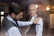 Tailor fitting businessman for suit in menswear shop — Stock Photo