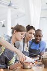 Friends enjoying cooking class in kitchen — Stock Photo