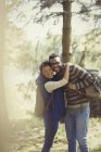 Portrait smiling couple with backpacks hiking in woods — Stock Photo