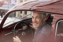 Portrait smiling mechanic inside classic car — Stock Photo