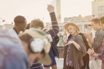 Young adult friends dancing at rooftop party — Stock Photo