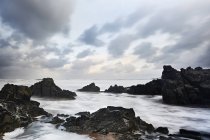 Rochas e oceano sob céu nublado, Devon, Reino Unido — Fotografia de Stock