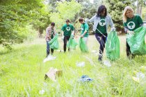Voluntarios ambientalistas recogiendo basura en el campo - foto de stock