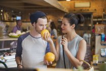 Couple smelling grapefruits in market — Stock Photo