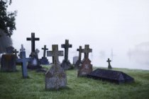 Cruzes em lápides no cemitério de nevoeiro etéreo — Fotografia de Stock