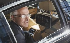 Бизнесмен смотрит в окно городской машины — стоковое фото