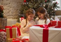 Дві сестри в оточенні різдвяних подарунків — стокове фото