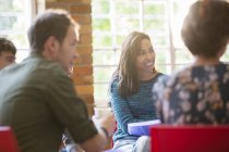 Smiling woman listening in group therapy session — Stock Photo