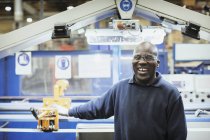 Retrato sonriente trabajador en la máquina en la fábrica de acero - foto de stock