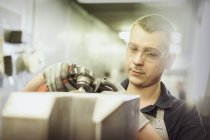 Worker using tool on part in steel factory — Stock Photo
