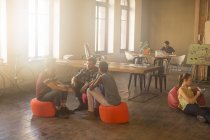 Gente de negocios casual reuniéndose en círculo en una oficina soleada - foto de stock
