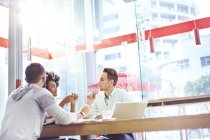 Business people meeting in sunny cafe — Stock Photo