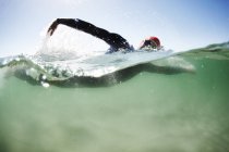 Male swimmer triathlete swimming in ocean — Stock Photo