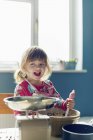 Sorridente ragazza cottura con ciotola di miscelazione in cucina — Foto stock