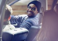 Lächelnder Mann fährt mit Freunden im Auto — Stockfoto