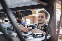 Mechaniker untersucht Autoteil in Autowerkstatt — Stockfoto
