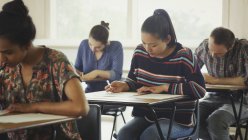 Студенти коледжу проходять тест за столом у класі — стокове фото