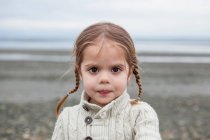 Портрет серйозної дівчини з плетеними кісками на пляжі — стокове фото