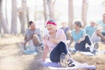 Sorridente donna anziana che pratica yoga nel parco soleggiato — Foto stock