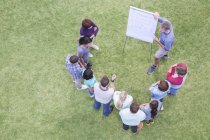 Man leading meeting at flipchart in field — Stock Photo