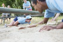 Männer krabbeln auf Boot-Camp-Hindernisparcours unter Netz — Stockfoto