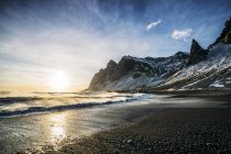 Pôr do sol sobre praia tranquila e montanha nevada, Islândia — Fotografia de Stock