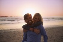 Retrato sorrindo casal abraço no pôr do sol praia — Fotografia de Stock