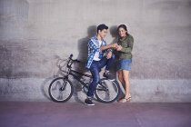 Підлітка пару з Bmx велосипеда текстові повідомлення на стіні — стокове фото