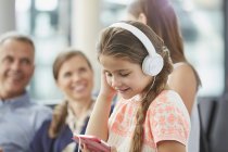 Девушка слушает музыку с наушниками и mp3-плеером — стоковое фото