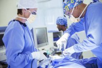 Chirurgiens opérant en salle d'opération — Photo de stock