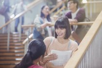 Female college students talking in stairway — Stock Photo