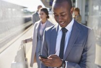 Geschäftsmann textet mit Handy auf Bahnsteig — Stockfoto