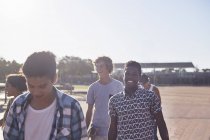 Sonrientes amigos adolescentes en el soleado parque de skate - foto de stock