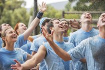 Enthusiastic team enjoying rain at boot camp — Stock Photo