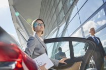 Businesswoman arriving at airport getting out of town car — Stock Photo
