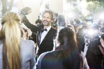 Celebrity waving at paparazzi photographers at event — Stock Photo