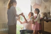 Donna incinta che riceve regalo in camera dei bambini — Foto stock