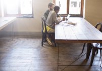 Творческие бизнесмены, работающие за ноутбуком в офисе — стоковое фото