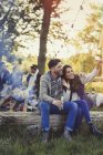 Casal posando para selfie com telefone da câmera perto da fogueira — Fotografia de Stock