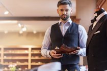 Портрет уверенный бизнесмен держа обувь в магазине мужской одежды — стоковое фото