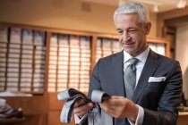Бізнесмен переглядає краватки в магазині чоловічого одягу — стокове фото