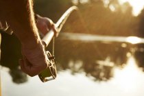 Gros plan senior homme mouche pêche au lac ensoleillé — Photo de stock