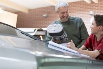 Батько і син відновлюють класичний автомобіль — стокове фото
